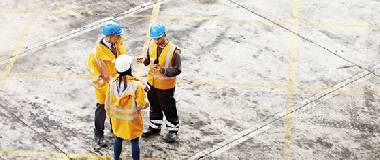 three construction employees talking on site
