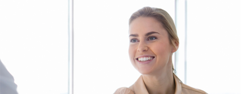 A woman shaking someone's hand and smiling