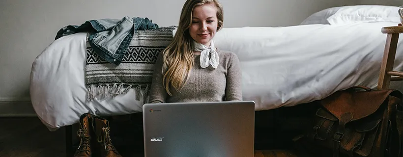 A woman sitting on the floor using her laptop