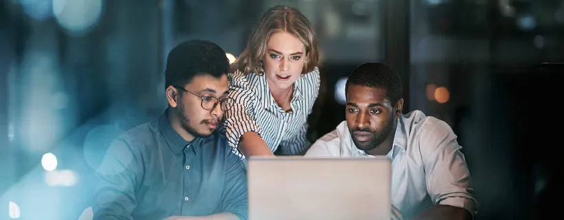 a group of coworkers looking at the computer screen