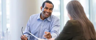 a male professional smiling at his co-worker