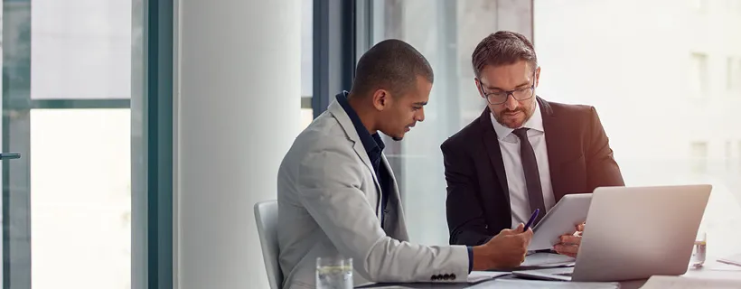 Two employees discussing a document