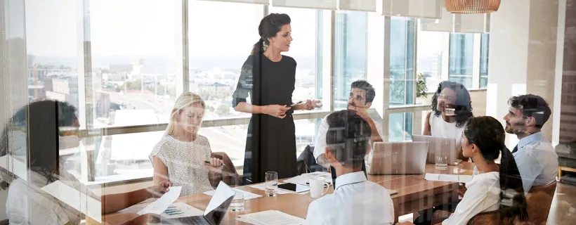 A team in the meeting room being led by their employer in discussion