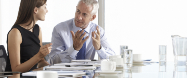 Two employees in a meeting room working