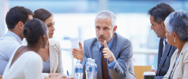 A boss his employees in discussion in the meeting room