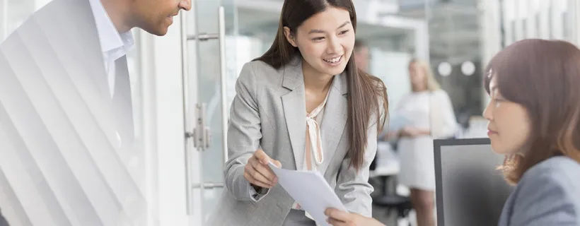 Three employees in the office meeting room working together