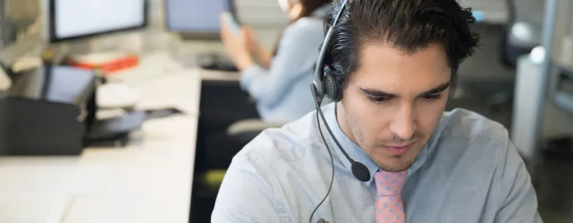 A man working in a call centre on the phone
