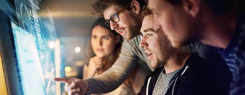 a group of coworkers looking at a computer screen