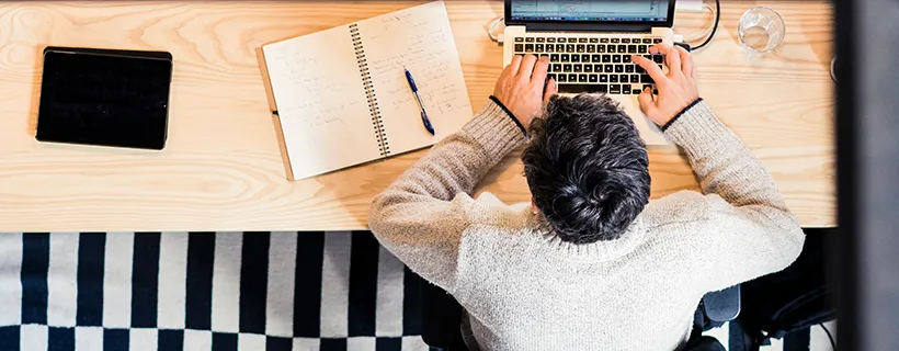 A man sitting at his desk from home working