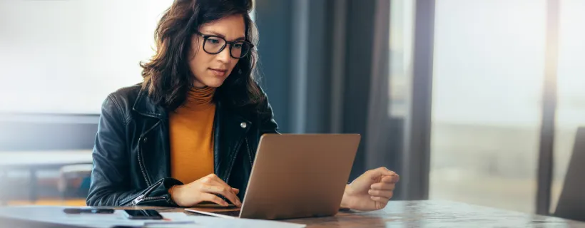 a girl with glasses working on her computer 