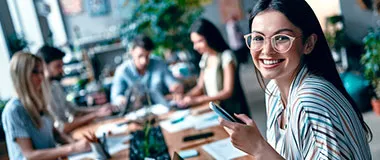 a girl holding her phone in an office space