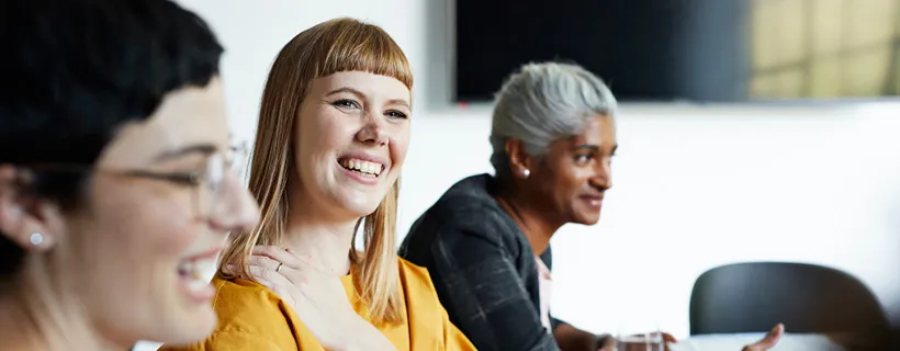 Three office leaders smiling and talking in the office