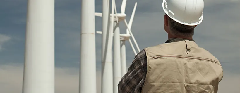 Man looking at turbines on wind energy farm