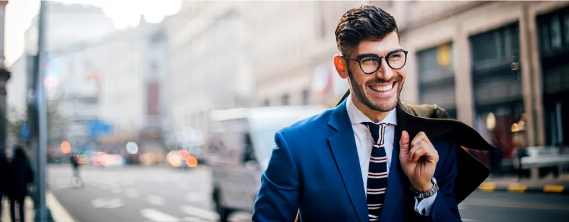 a young professional wearing glasses smiling and walking