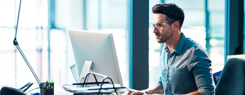 an HR with glasses working on his computer