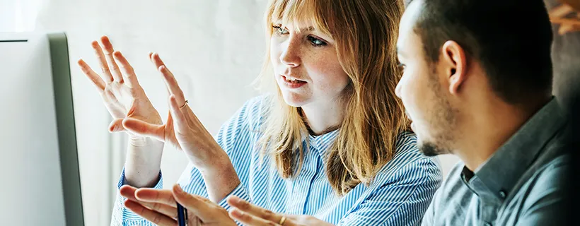 two HR professionals working together on one computer