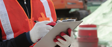 A construction worker writing on a notepad