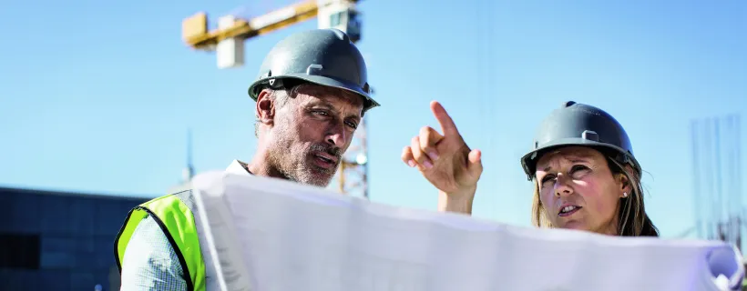 Two construction workers looking at blueprints