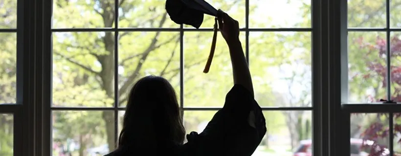 A university graduate raising her hat