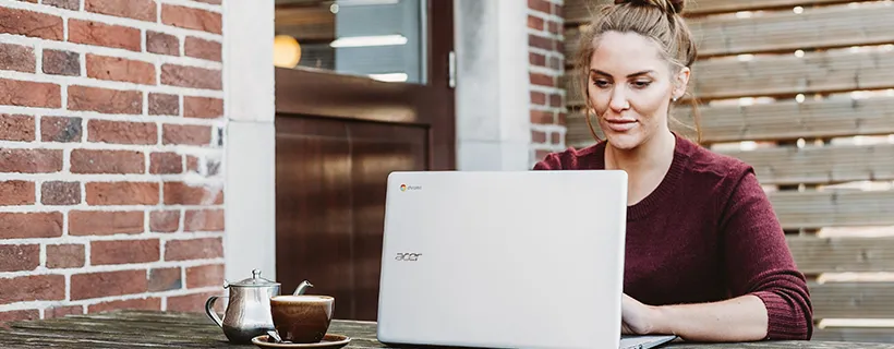 A woman sitting outside using her computer