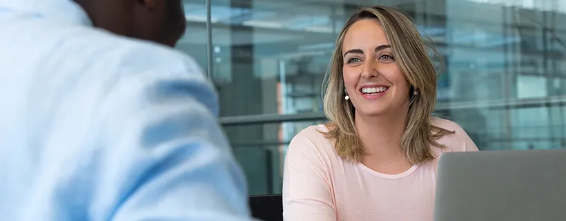 Two people smiling and working in the office