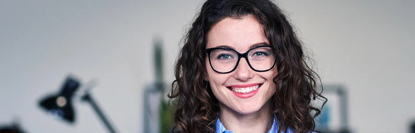 a girl with glasses smiling