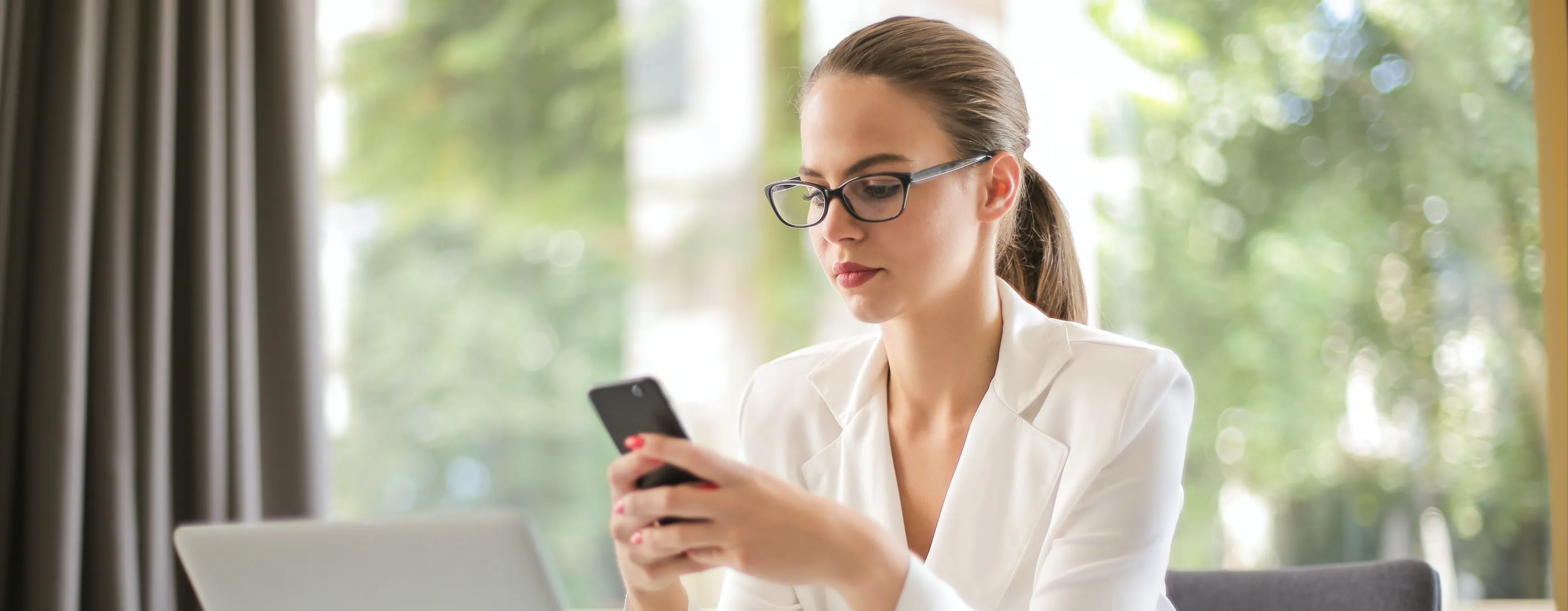 a woman looking at her phone checking for job alerts