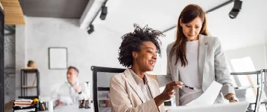 two female colleagues looking at a paper