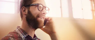 a guy with glasses talking on the phone