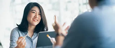 An employee holding a tablet device and smiling