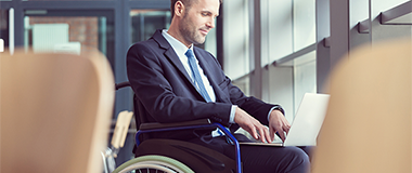 A man in a wheelchair on his laptop