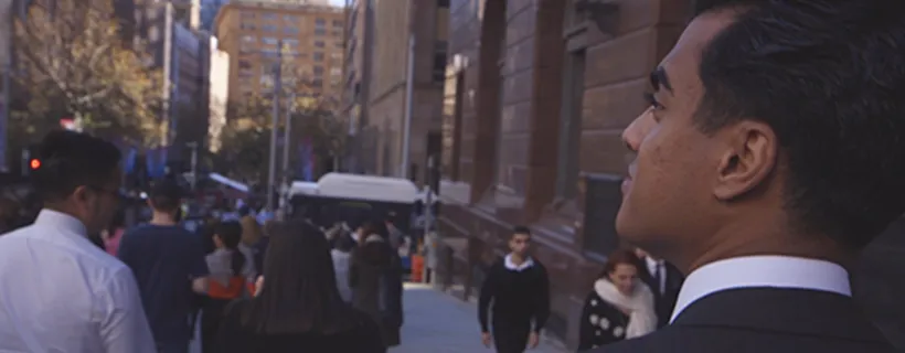 A man walking through the city looking at the buildings