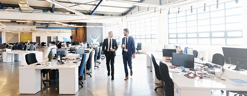 Two employees walking through the office