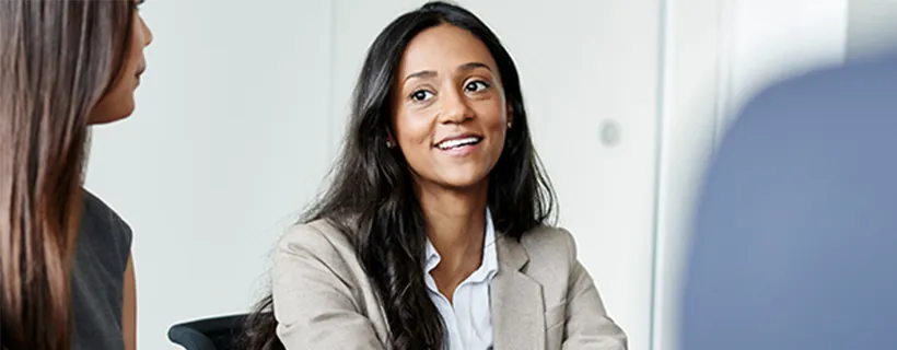 a woman in a meeting talking to her employees