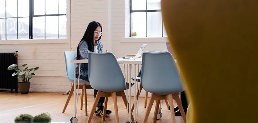 A woman sitting alone in her office working on her laptop