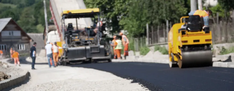 Heavy construction machinery paving concrete on a site