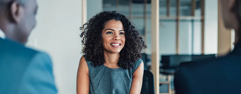 Three employees in the office smiling