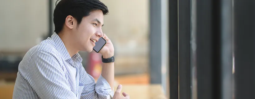 A man on his phone staring out the window