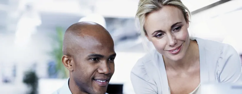 Two employees working together on a computer