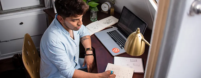 A man at his desk working on a design