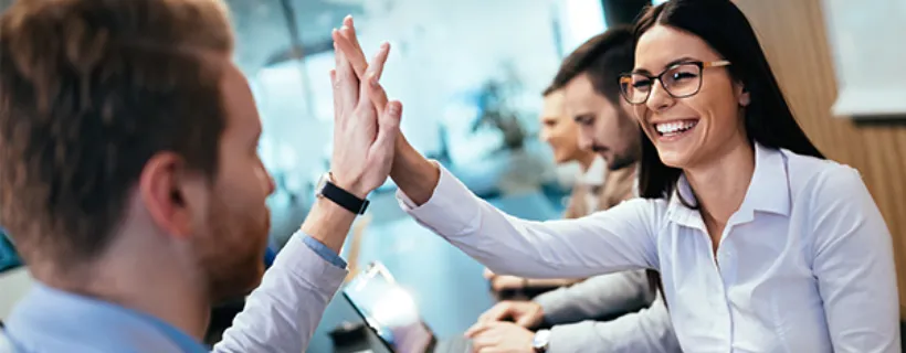 Two employees hi fiving after a successful meeting