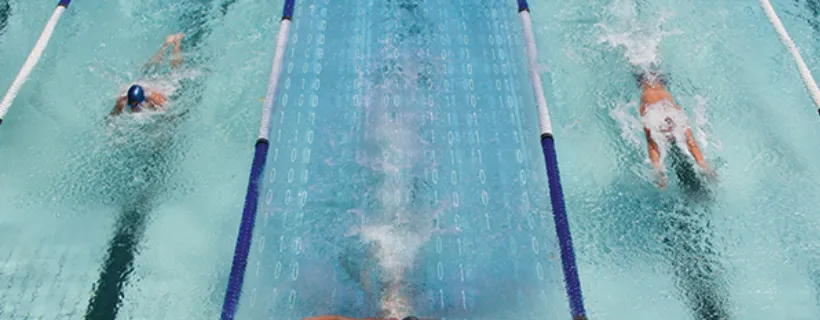 three people swimming laps in a pool