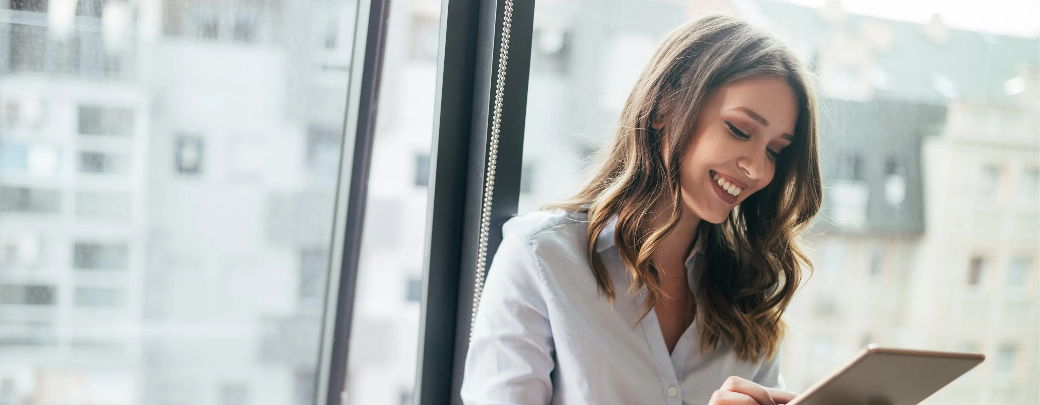 A woman smiling and using a tablet