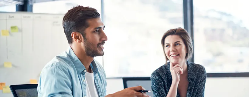 two employees laughing and talking in an office