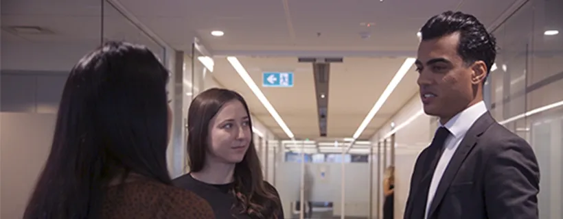 Three Hays employees standing in the office hall talking