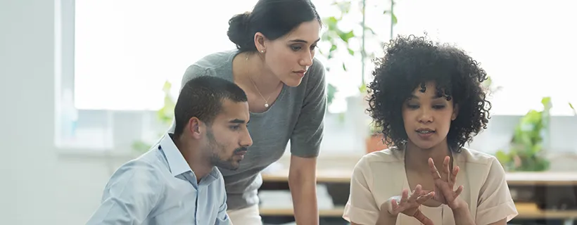 Three employees working together on a group task